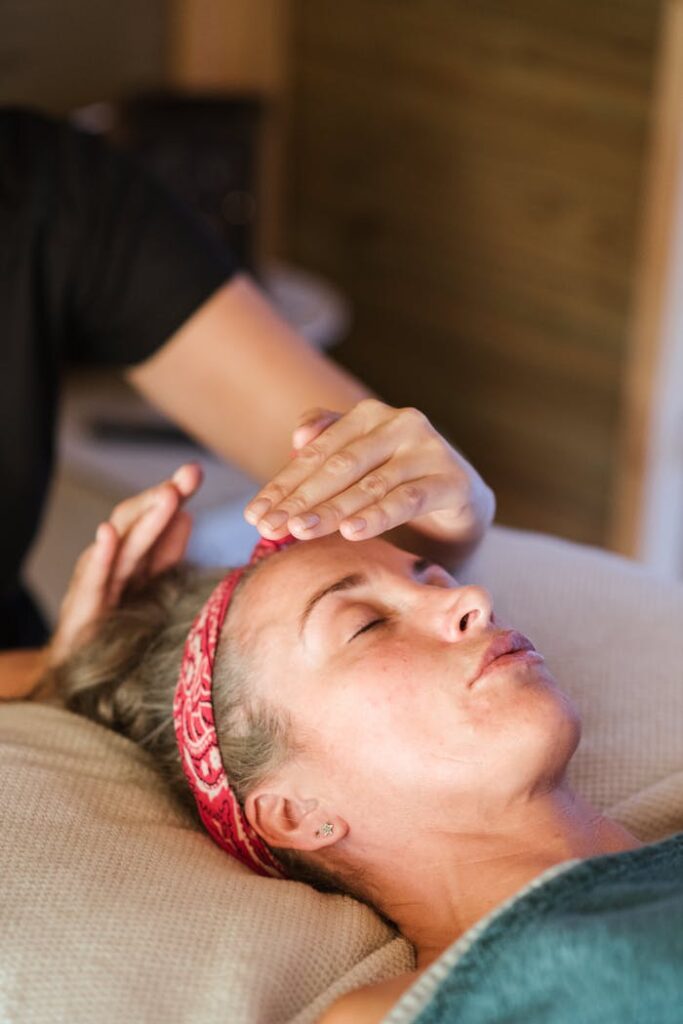 A woman enjoying a peaceful reiki session in a cozy spa setting for ultimate relaxation.